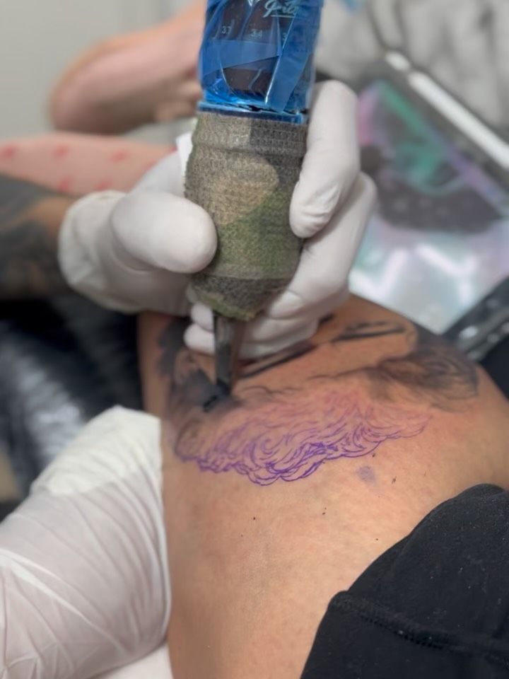 Mano con guantes tatuando el pelo de un retrato sobre el esténcil violeta