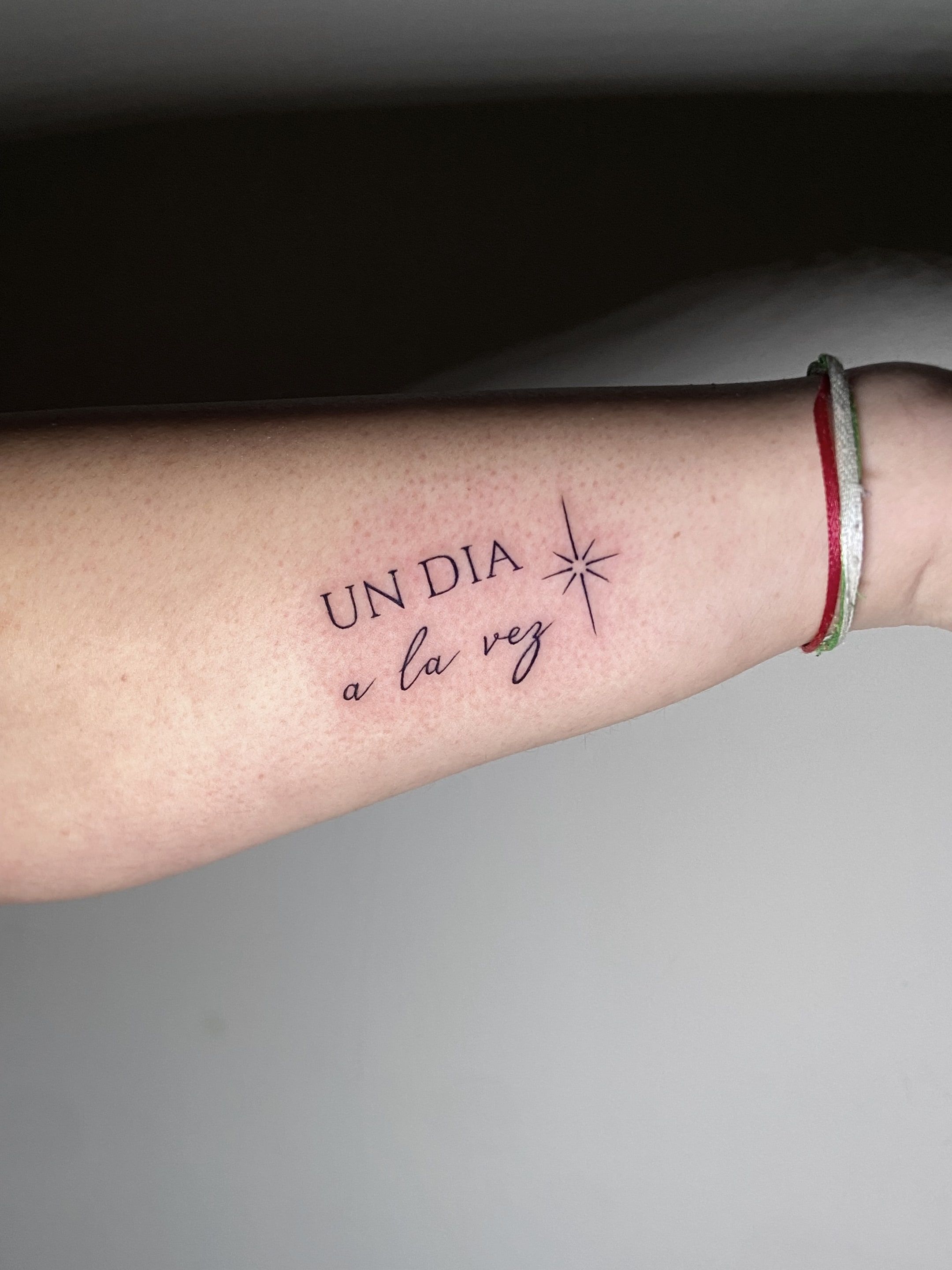 Frase en línea fina "Un día a la vez" con una estrella de cuatro puntas